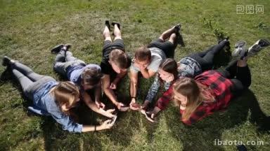 <strong>最好</strong>的朋友在圈里用手机社交，躺在公园的草地上俯视图